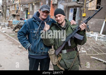 Marioupol, Ukraine. 03rd avril 2022. Un soldat de la République populaire de Donetsk avec un civil à Marioupol. La bataille entre les forces russes et pro-russes et les forces ukrainiennes en déférence, sous la direction du bataillon Azov, se poursuit dans la ville portuaire de Marioupol. Crédit : SOPA Images Limited/Alamy Live News Banque D'Images