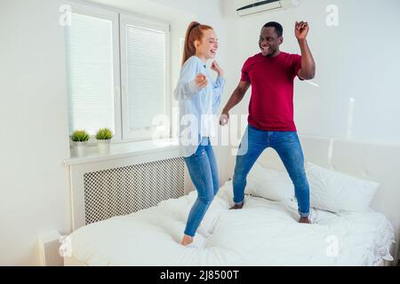 latino hispanique petit ami et redhaired ginger petite amie sauter sur le lit le matin.déménagement à louer la maison Banque D'Images