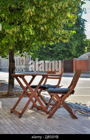 Table et chaises vides dans un café de rue. Café-terrasse sans personnes ni clients. Problèmes et crise de l'industrie alimentaire et des petites entreprises Banque D'Images