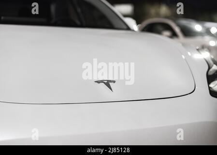 Logo de la société Tesla sur le capot avant de la voiture électrique. L'insigne de Tesla Motors sur un capot blanc de véhicule électrique Banque D'Images