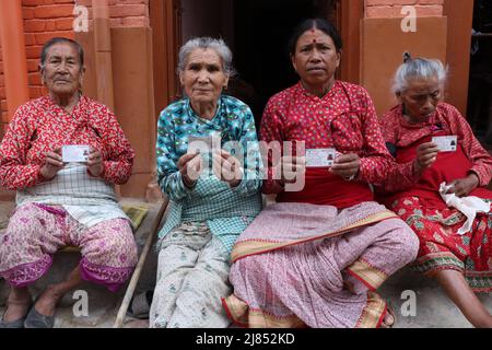 Katmandou, ne, Népal. 13th mai 2022. Les femmes âgées montrent leurs cartes d'identité après avoir fait leurs votes lors des élections locales à Khokana, dans le district de Lalitpur, à Katmandou, au Népal, le 13 mai 2022. (Image de crédit : © Aryan Dhimal/ZUMA Press Wire) Banque D'Images