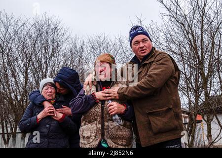 Lipovka, Ukraine. 10th avril 2022. Les parents et les amis pleurent lorsque la police arrive pour recueillir le corps d'un homme mort pour enquête. Selon sa famille, l'homme a été empoisonné par des soldats russes.Lipovka est une petite ville de la région de Bucha située à 60 km à l'ouest de la capitale. Une zone complète de petits villages qui n'ont pas de lumière, d'eau, de gaz, de chaleur et de communication depuis plus d'un mois. Lipovka a été détruite par environ 40%, des meurtres de masse de civils par les occupants russes ont été enregistrés, des infrastructures ont été détruites, des territoires ont été extraits. (Image de crédit : © Rick Mav Banque D'Images