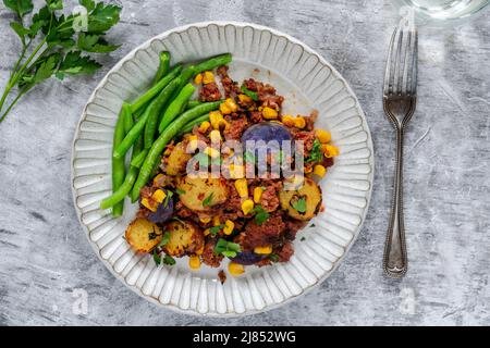 Bœuf corné, maïs sucré et hash de pomme de terre avec haricots verts Banque D'Images