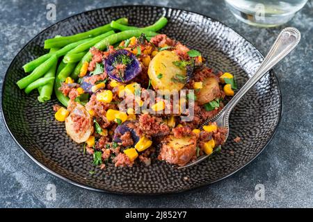 Bœuf corné, maïs sucré et hash de pomme de terre avec haricots verts Banque D'Images