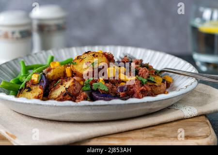 Bœuf corné, maïs sucré et hash de pomme de terre avec haricots verts Banque D'Images