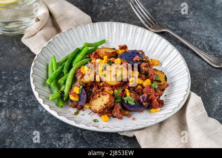 Bœuf corné, maïs sucré et hash de pomme de terre avec haricots verts Banque D'Images