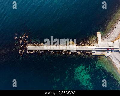 Au-dessus de la vue panoramique aérienne du mur brise-lames en béton dans la mer claire ou l'eau de l'océan plage de rivage. Drone pov wave Storm protection Rock Pier Banque D'Images