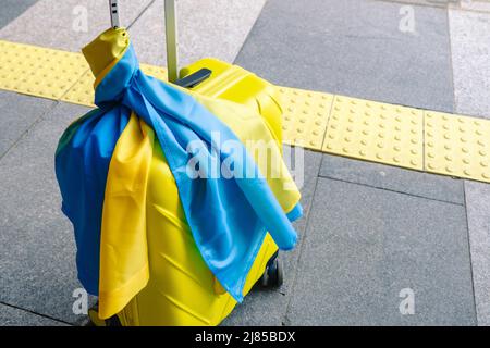 valise jaune avec drapeau ukrainien à la gare d'immigration réfugié Banque D'Images