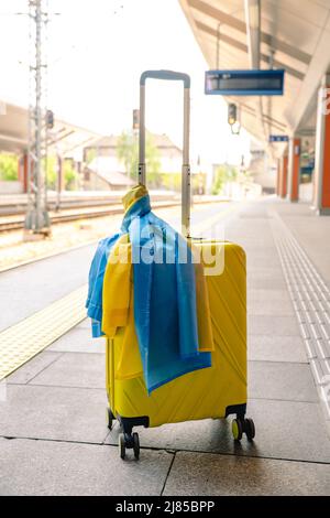 valise jaune avec drapeau ukrainien à la gare d'immigration réfugié Banque D'Images