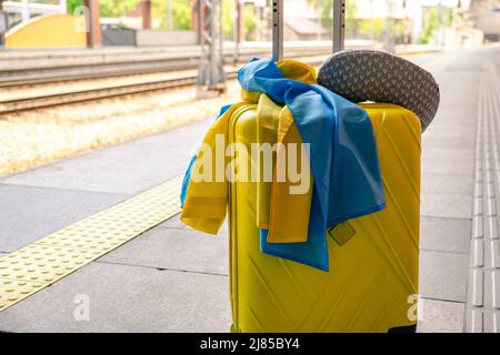 valise jaune avec drapeau ukrainien à la gare d'immigration réfugié Banque D'Images