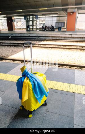 valise jaune avec drapeau ukrainien à la gare d'immigration réfugié Banque D'Images