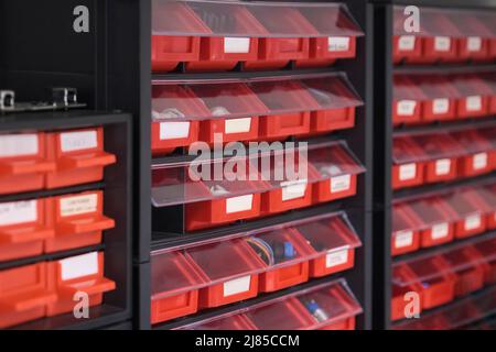 Vis dans des boîtes de rangement orange dans un atelier Photo Stock - Alamy