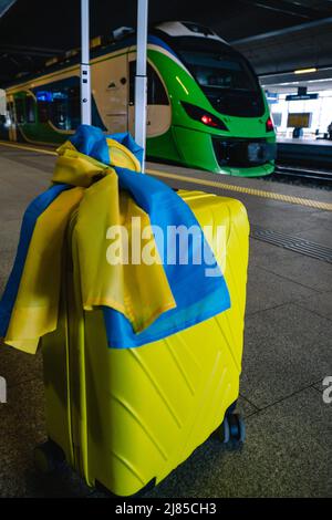 valise jaune avec drapeau ukrainien à la gare d'immigration réfugié Banque D'Images