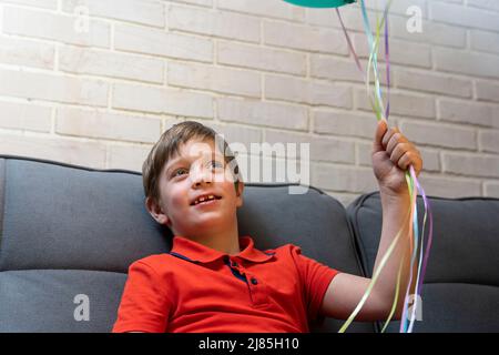 un garçon d'âge préscolaire heureux tient des ballons dans ses mains Banque D'Images