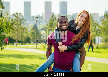 Portrait d'un jeune homme qui embrasse sa petite amie debout ensemble sur un parc d'été de printemps par une journée ensoleillée Banque D'Images