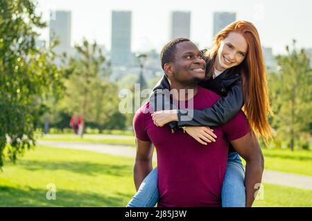 Portrait d'un jeune homme qui embrasse sa petite amie debout ensemble sur un parc d'été de printemps par une journée ensoleillée Banque D'Images