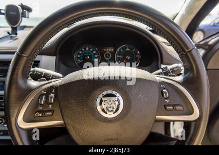 Volant et tableau de bord d'une Jaguar XF avec boutons de la radio et du régulateur de vitesse sur le volant. Banque D'Images