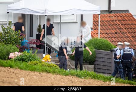 Eberdingen, Allemagne. 13th mai 2022. Les hommes portent un cercueil hors d'une maison où l'on soupçonne qu'un homme a tué sa femme, sa fille et lui-même. Credit: Christoph Schmidt/dpa - ATTENTION: Personne(s) ont été pixelated pour des raisons juridiques/dpa/Alamy Live News Banque D'Images