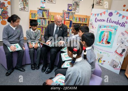 Le secrétaire à l'éducation Nadhim Zahawi lit le livre commémoratif du Jubilé avec les élèves de l'an 5 lors d'une visite à l'école primaire de Manor Park à Sutton. Date de la photo: Vendredi 13 mai 2022. Banque D'Images