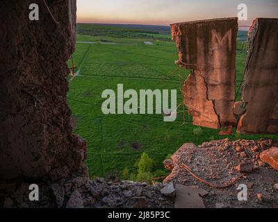 Kharkiv, Kharkov, Ukraine - 05.07.2022: Vue intérieure de la chambre détruite d'appartement civil sur le terrain avec herbe verte mur en béton brisé dans la maison Banque D'Images