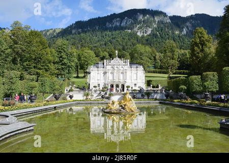 Vue sur le palais de Linderhof (dans le sud-ouest de la Bavière, près du village d'Ettal) et une statue de la femme et des enfants d'or au jardin du palais Banque D'Images