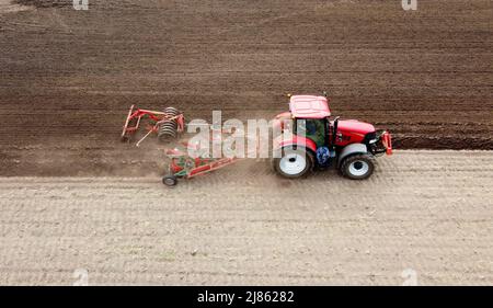 Un agriculteur labour ses terres agricoles sèches au printemps. Banque D'Images