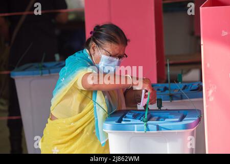 Lalitpur, Népal. 13th mai 2022. Une femme lance son bulletin de vote à un bureau de vote lors des élections locales à Lalitpur, au Népal, le 13 mai 2022. Credit: Hari Maharajan/Xinhua/Alamy Live News Banque D'Images