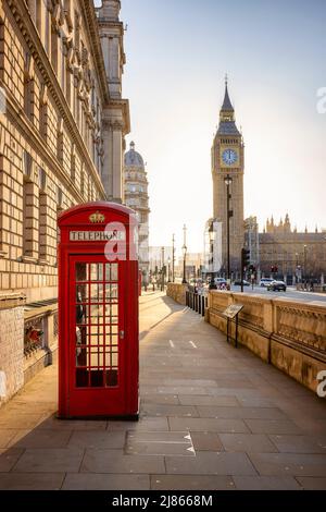 Une cabine téléphonique rouge classique devant le clocher de Big Ben à Londres Banque D'Images