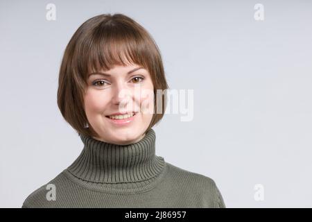 jeune femme heureuse dans un chandail vert Banque D'Images