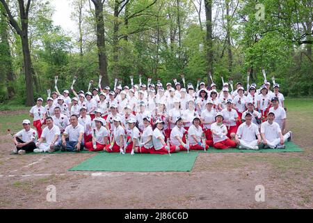 Des femmes chinoises et quelques hommes de la troupe de danse Kai Xin Yizhu célèbrent la fête des mères en posant pour une photo de groupe tout en tenant des roses. Dans un parc à New York. Banque D'Images