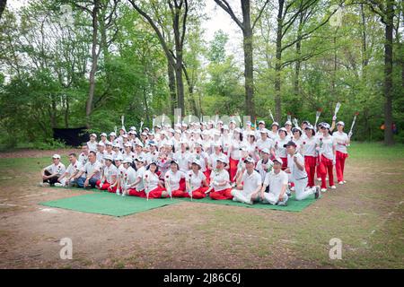 Des femmes chinoises et quelques hommes de la troupe de danse Kai Xin Yizhu célèbrent la fête des mères en posant pour une photo de groupe tout en tenant des roses. Dans un parc à New York. Banque D'Images