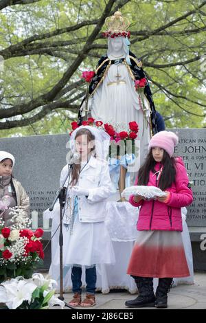 Une jeune fille de 8 ans dirige un service de la fête des mères « May Crowning » des catholiques romains dévots dans un parc à Queens, New York Banque D'Images