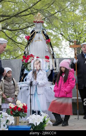 Une jeune fille de 8 ans dirige un service de la fête des mères « May Crowning » des catholiques romains dévots dans un parc à Queens, New York Banque D'Images