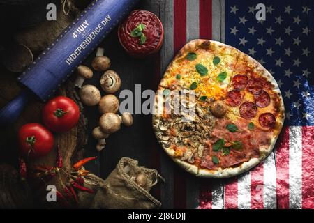 Pizza avec différents ingrédients sur la table en bois dans la cuisine. Pizza de style américain. Heureux 4th de juillet. Concept de la nourriture de jour d'indépendance Banque D'Images