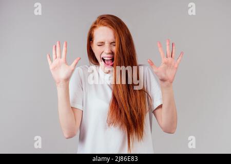 redhair ginger femme en coton vert soie robe en studio rose sensation stupéfait Banque D'Images