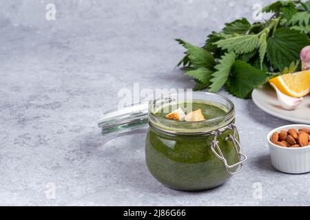 Soupe d'orties faite à partir de pousses jeunes. Dans un pot en verre, ortie, ail, amande, jus de citron, huile et décoré de croûtons. Espace pour le texte Banque D'Images