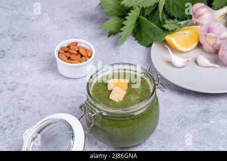 Soupe d'orties faite à partir de pousses jeunes. Dans un pot en verre, ortie, ail, amande, jus de citron, huile et décoré de croûtons. Espace pour le texte Banque D'Images