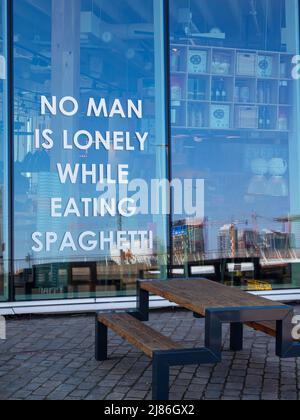 Rotterdam, pays-Bas - 28 avril 2022 : inscription sur la fenêtre du restaurant italien : aucun homme n'est seul en mangeant des spaghetti Banque D'Images