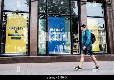 Kiev, Ukraine. 13th mai 2022. Homme marchant par de grands panneaux dans les fenêtres du magasin disant «Bravery is Ukrainian brand» et «Bravery made in Ukraine». (Photo de Michael Brochstein/Sipa USA) crédit: SIPA USA/Alay Live News Banque D'Images