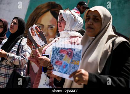 Gaza, bande de Gaza, Palestine. 12th mai 2022. Gaza, Palestine. Mai 12. Des artistes palestiniens peignent une fresque dans la ville de Gaza en hommage à Shireen Abu Aqleh, journaliste tué d'Al-Jazeera. Le journaliste Abu Aqleh a été abattu par des soldats israéliens lors d'un raid israélien dans le camp de réfugiés de Jénine, dans le nord de la Cisjordanie, au début de mercredi (Credit image: © Yousef Mohammad/IMAGESLIVE via ZUMA Press Wire) Banque D'Images