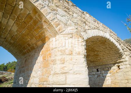 Un pont en pierre médiéval construit en pierre courgée dans le village d'Alethriko sur l'île de Chypre. Banque D'Images
