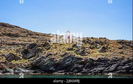 Petite église grecque sur la colline rocheuse, vue de la mer, ciel bleu, jour d'été ensoleillé. Chapelle Agios Ioannis, île de Kythnos, Grèce Banque D'Images