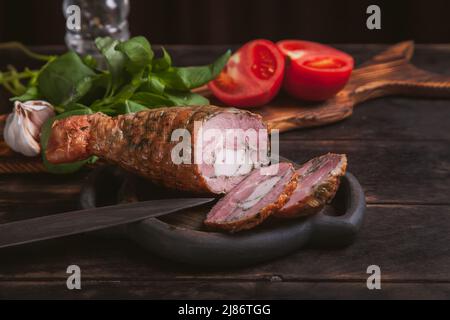 Trancher d'une viande de dinde artisanale maison, bouillie et fumée avec l'ajout de filet de poulet dans la peau d'une jambe de poulet avec un os Banque D'Images