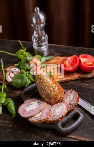 Trancher d'une viande de dinde artisanale maison, bouillie et fumée avec l'ajout de filet de poulet dans la peau d'une jambe de poulet avec un os Banque D'Images