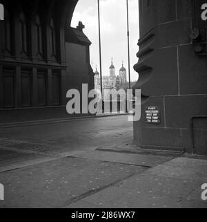 1950s, historique, vue sur la Tour de Londres à travers l'une des arches de la tour sur Tower Bridge, Londres, Angleterre, Royaume-Uni. Avis sur la voûte plantaire rappelant aux gens - les passagers à pied - de ne pas marcher sur la route sous la voûte plantaire. Banque D'Images