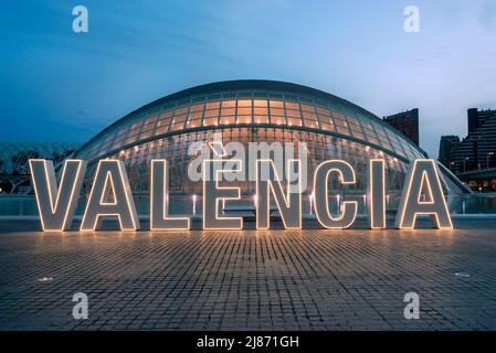 Ilumianted Valencia Neon signe en face de l'édifice hémisferique de la ville des arts et des sciences. Banque D'Images