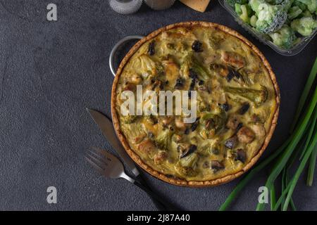 Quiche au poulet, aux champignons et au brocoli, tarte française traditionnelle maison sur fond gris foncé, vue d'en haut Banque D'Images