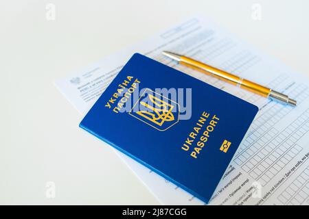 Document PESEL, passeport ukrainien et stylo sur fond de table blanc. Banque D'Images