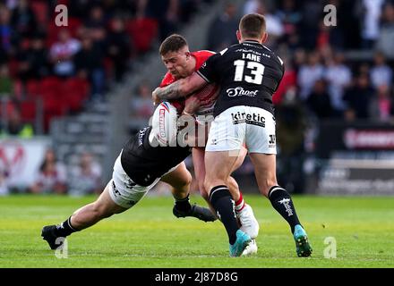 Le centre de St Helens, Morgan Knowles, est attaqué par Scott Taylor (à gauche) du FC Hull et Jordan Lane lors du match de la Super League de Betfred au stade totalement Wicked, St Helens. Date de la photo: Vendredi 13 mai 2022. Banque D'Images