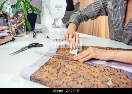 Portrait d'une couturière dans une veste à carreaux travaillant dans son atelier de couture, elle montrant l'intérieur de la doublure de vêtements Banque D'Images